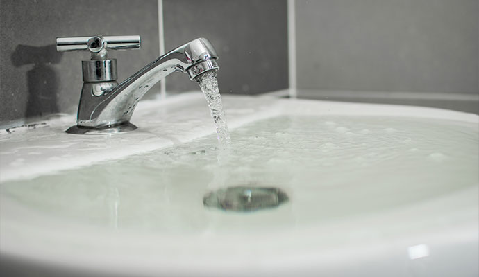 The bathroom sink is overflowing with water.