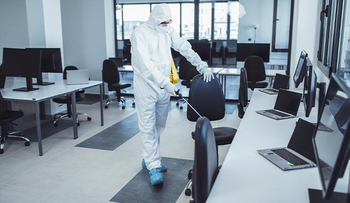 Professional worker disinfecting a office space