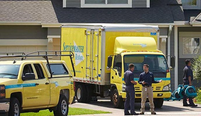 ServiceMaster Professional Restoration service team with service vehicles