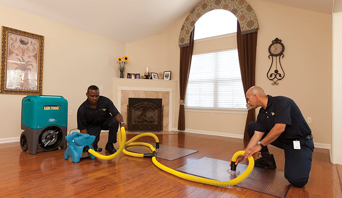 worker extracting floor water with equipment in dayton